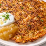 Golden brown crispy savory red lentil pancakes stacked on a plate, with a creamy dip and fresh herbs, showing crunchy texture and appetizing color.