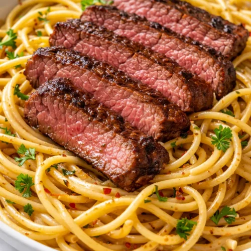 Creamy garlic butter steak pasta with tender strips of beef and al dente penne in a rich, buttery sauce.