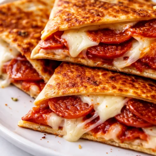 Crispy golden brown pizza quesadillas with melted mozzarella and pepperoni, served with marinara sauce for dipping.