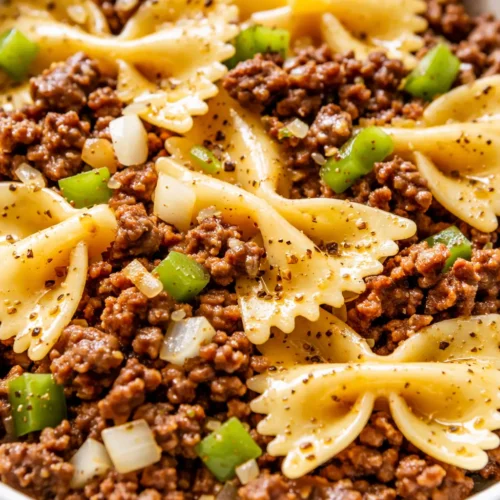 Garlic butter bowtie pasta with beef, golden butter sauce coating tender farfalle and browned ground beef, topped with fresh parsley.