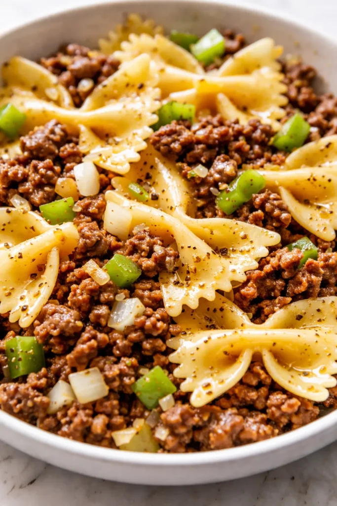 Garlic butter bowtie pasta with beef, golden butter sauce coating tender farfalle and browned ground beef, topped with fresh parsley.