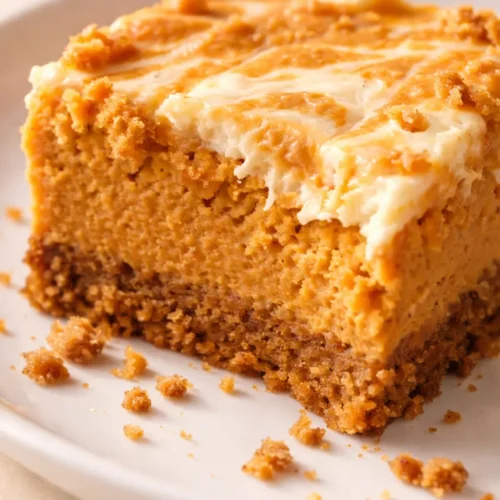 Creamy gluten free pumpkin pie cheesecake bars with spiced pumpkin swirl and golden graham cracker crust, an indulgent dessert