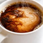 Iced brown sugar oatmilk shaken espresso in a clear glass, with rich caramel tones and creamy oat milk swirls over ice.
