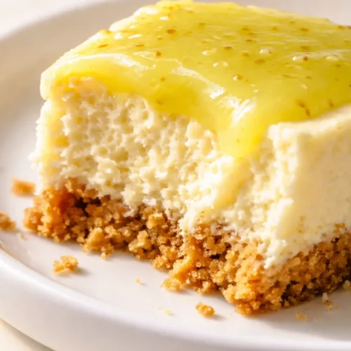 Smooth key lime cheesecake slice on a white plate showing creamy pale green filling and golden graham cracker crust
