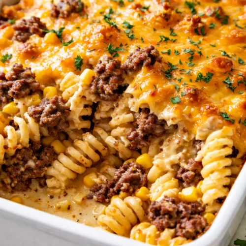 Golden brown loaded cheddar ranch beef and sweet corn rotini bake in a baking dish, creamy and cheesy with visible corn kernels and ground beef.