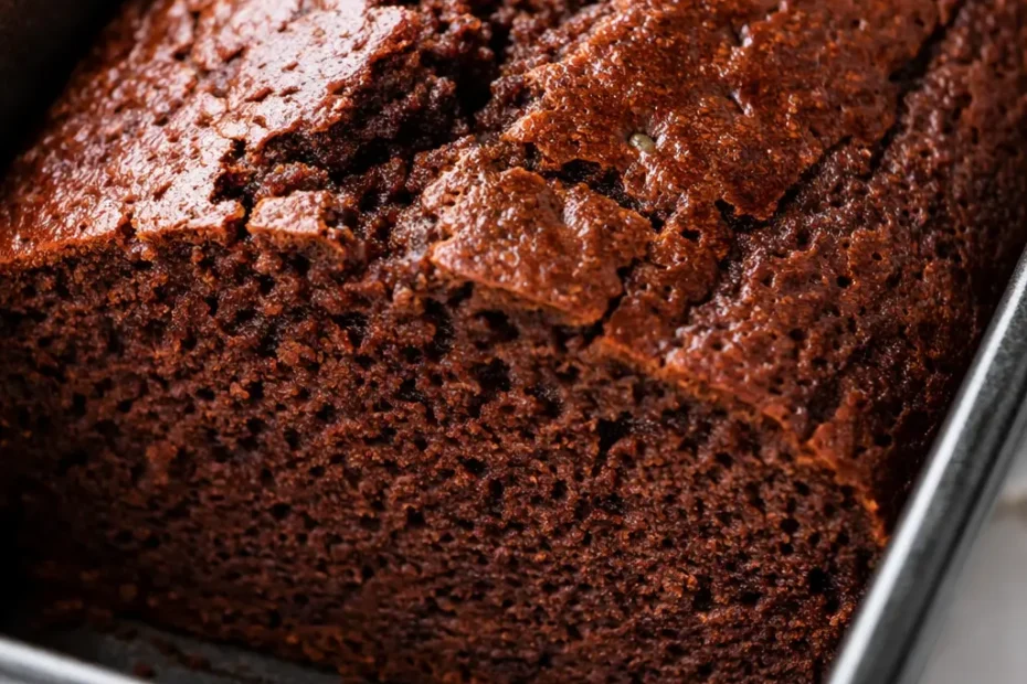 Moist gluten free chocolate banana bread slice with melted chocolate chips, rich brown crumb, and visible banana flecks.
