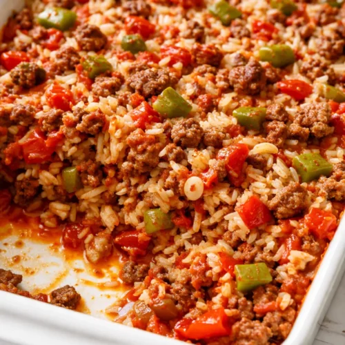 Golden baked stuffed pepper casserole with ground beef, rice, tomato sauce, and melted cheese, garnished with fresh parsley.