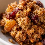 Golden brown almond flour granola clusters with dried fruit and cardamom, perfectly crisp and textured