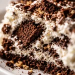 Sliced classic icebox cake showing layers of chocolate wafers and whipped cream, creamy texture
