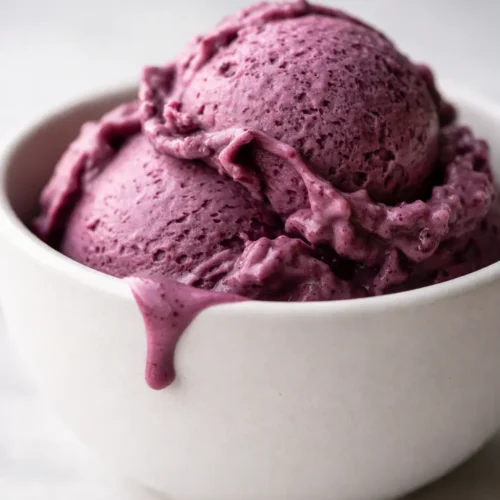 Creamiest Ninja Creami blueberry cheesecake protein ice cream in a pint, smooth creamy texture with berry swirl and graham crumble