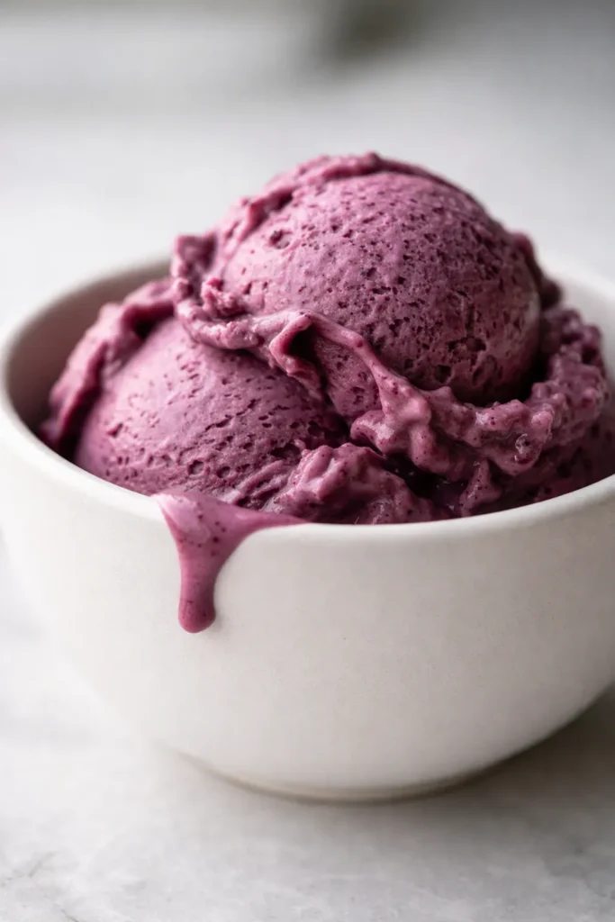 Creamiest Ninja Creami blueberry cheesecake protein ice cream in a pint, smooth creamy texture with berry swirl and graham crumble