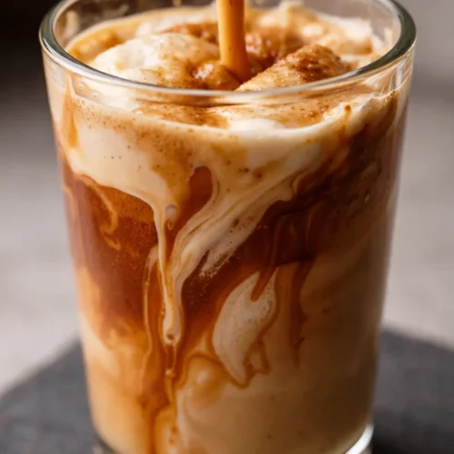 Iced Hocus Pocus latte with white mocha sauce, apple brown sugar syrup, and caramel drizzle, topped with cinnamon dolce