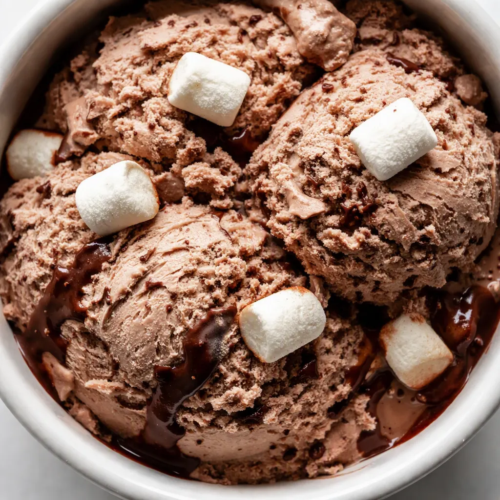 Ninja Creami frozen hot chocolate ice cream batter in a pint, smooth dark cocoa texture with mini marshmallows