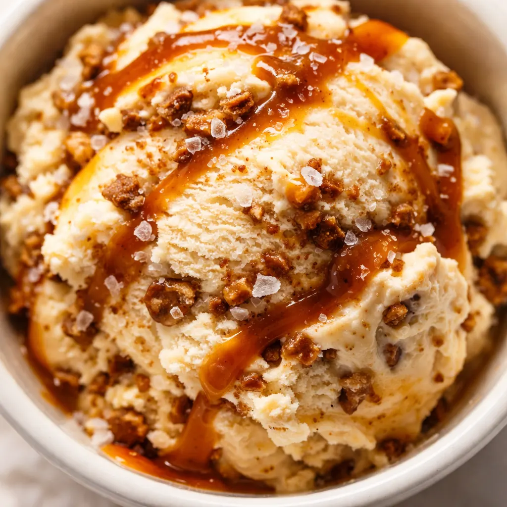 Pouring creamy salted caramel ice cream base into Ninja Creami pint, golden caramel swirls and smooth texture visible