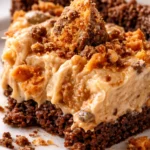 Creamy no-bake Butterfinger pie slice with crunchy graham cracker crust and chocolate crumbles on top