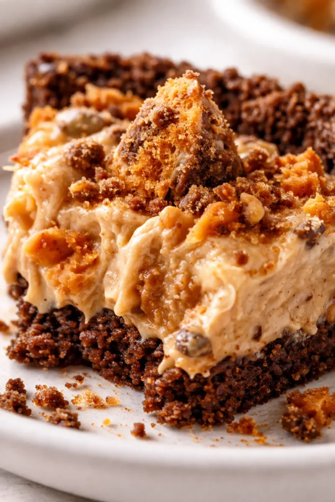 Creamy no-bake Butterfinger pie slice with crunchy graham cracker crust and chocolate crumbles on top