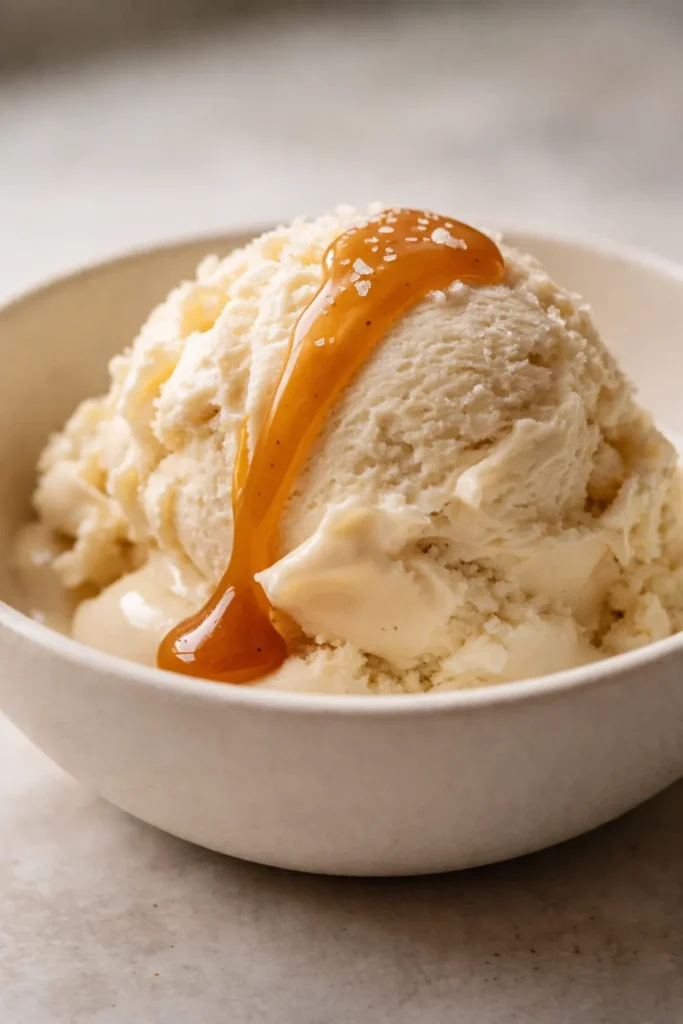 Creamy Ninja Creami salted caramel protein ice cream in a bowl, smooth texture with caramel swirls and flaky sea salt on top