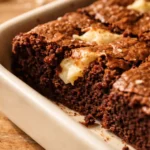Golden white chocolate brownies cut into squares, showing a creamy crackly top and gooey texture