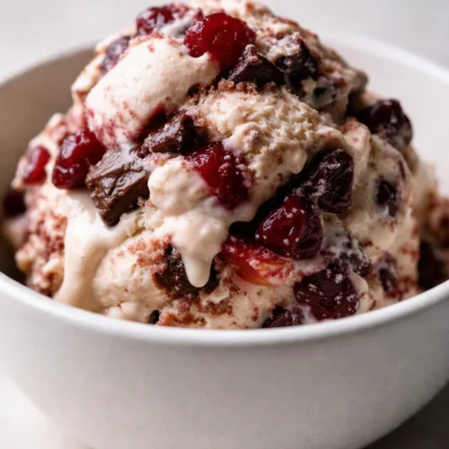 Creamy cherry vanilla ice cream with dark chocolate chunks and vibrant red cherries in a chilled glass bowl