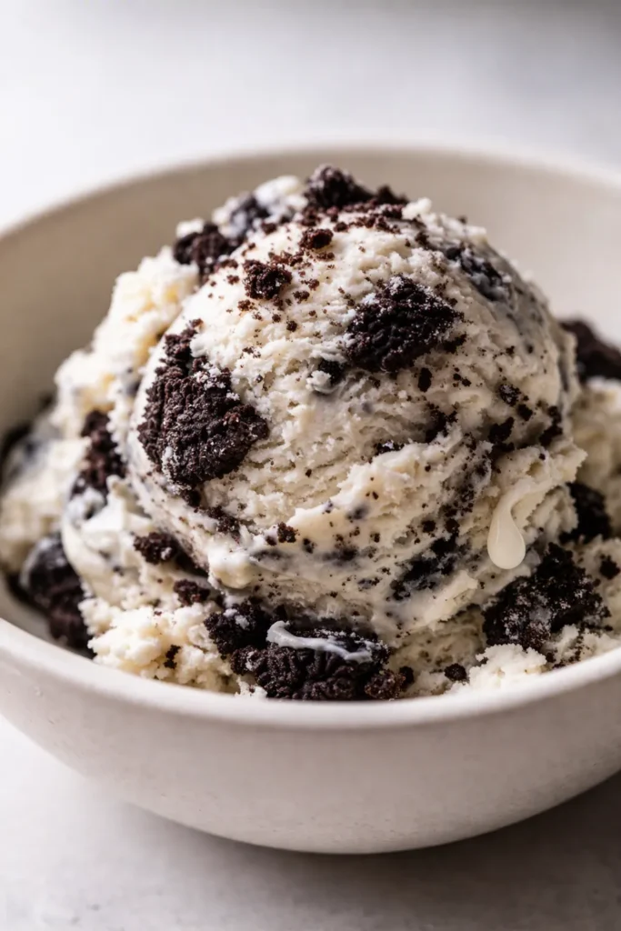 Creamy Ninja Creami cookies and cream ice cream in a bowl, swirled with chocolate Oreo chunks and a smooth, velvety texture